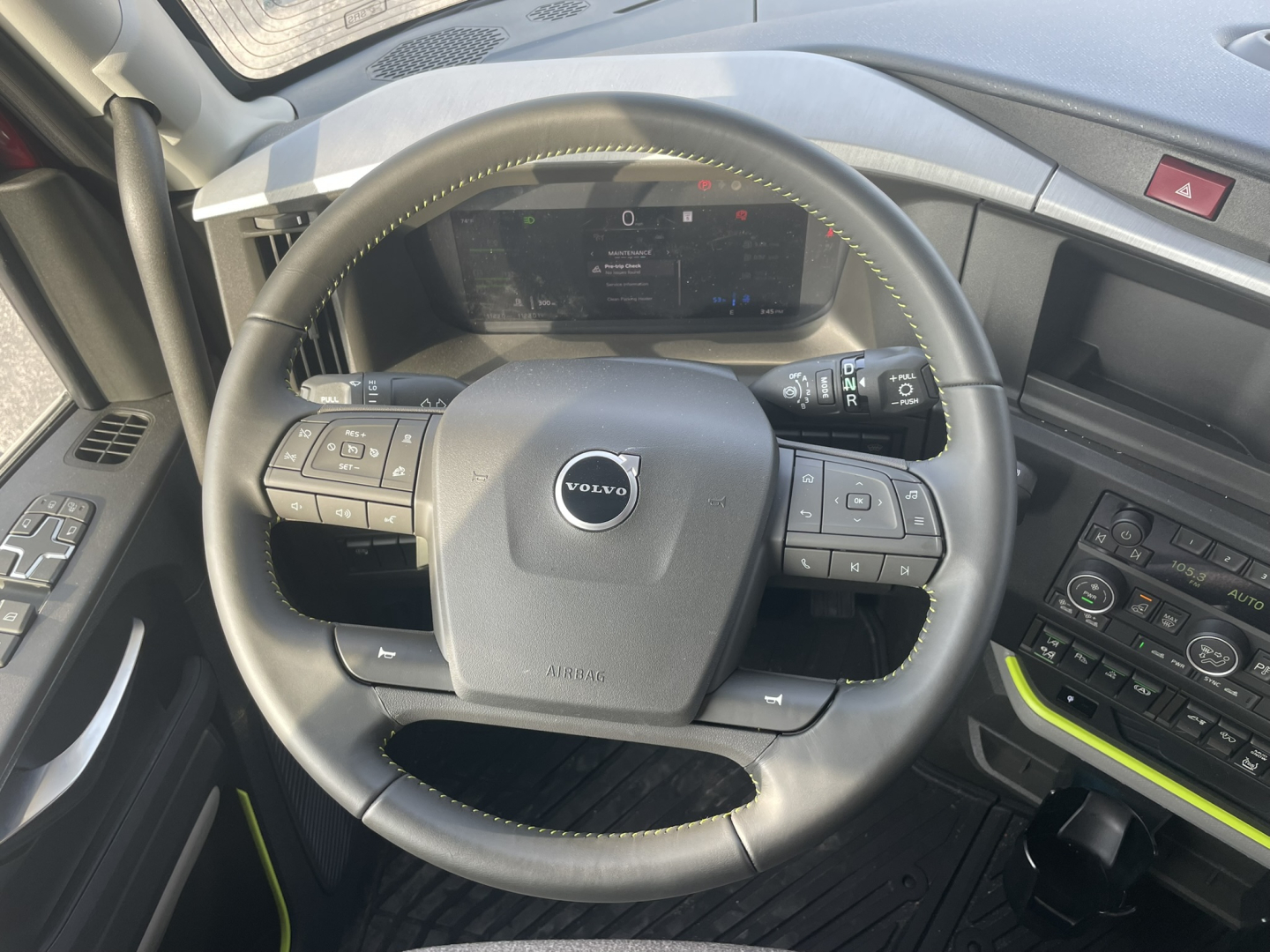 Volvo VNL64T860 steering wheel and dashboard view showing cabin controls and digital gauge cluster.