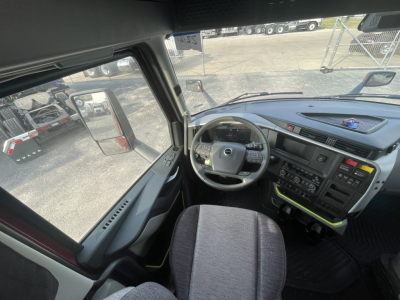 Volvo VNL64T860 truck cab interior showing steering wheel/dash with multiple controls and driver seat.