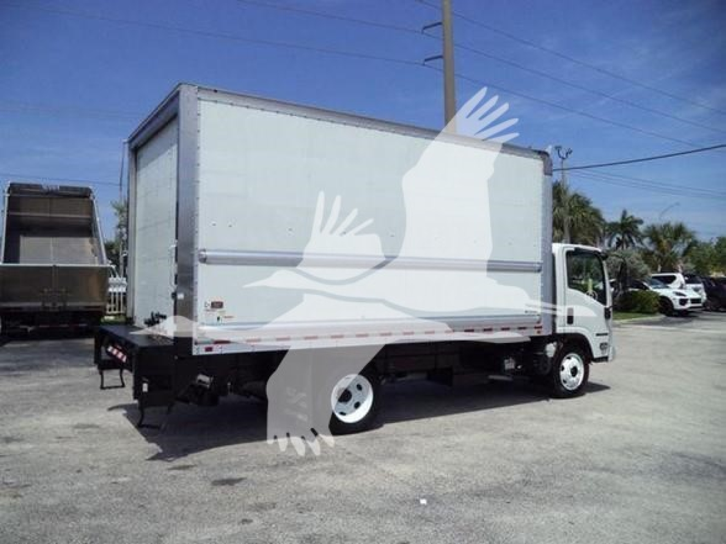Box truck, 2020 Isuzu NPR-HD, side view showing cargo box and cab with white wheels.
