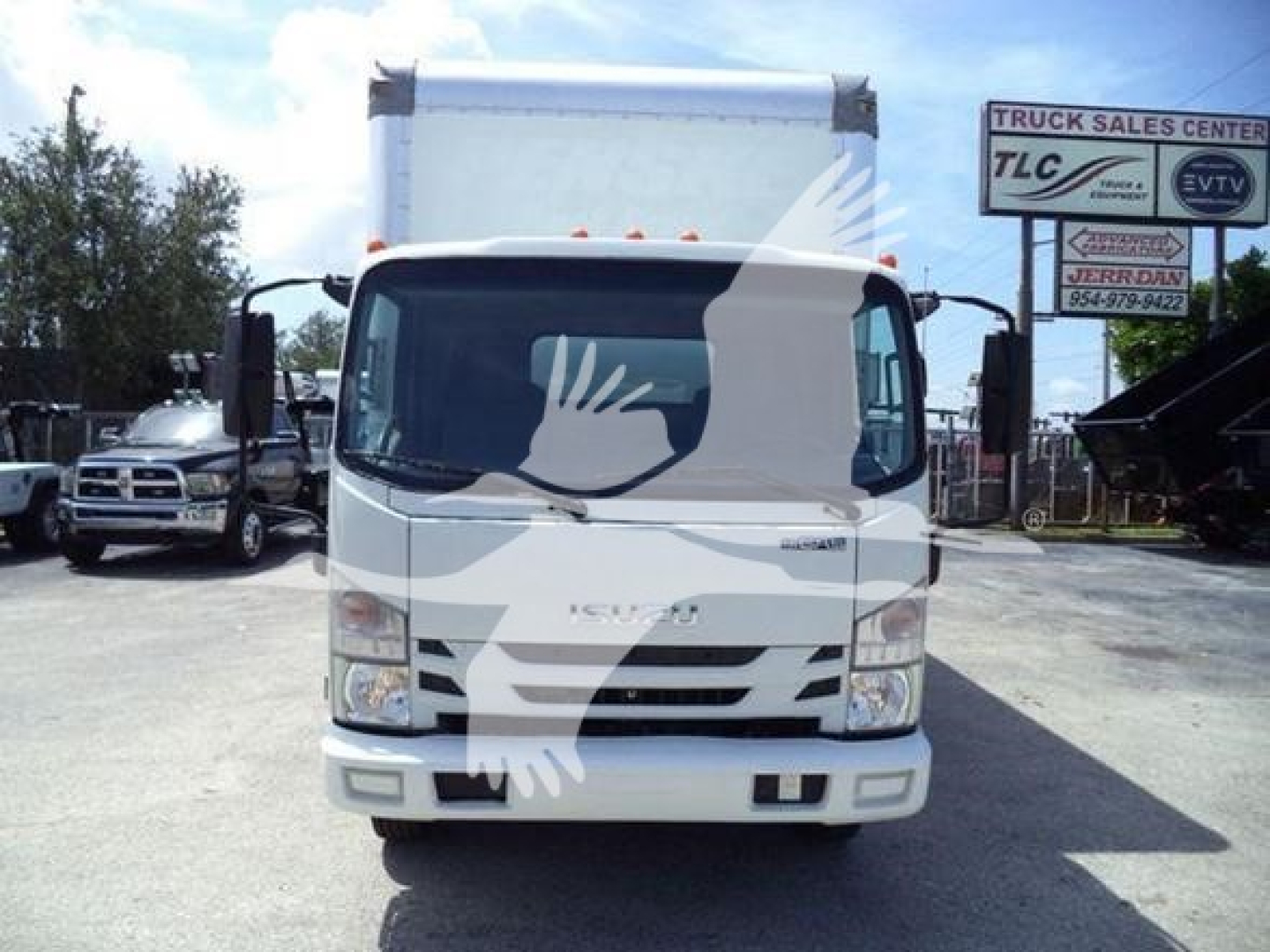 Isuzu NPR HD box truck front view with cab and cargo area, white color, dealership lot in background.
