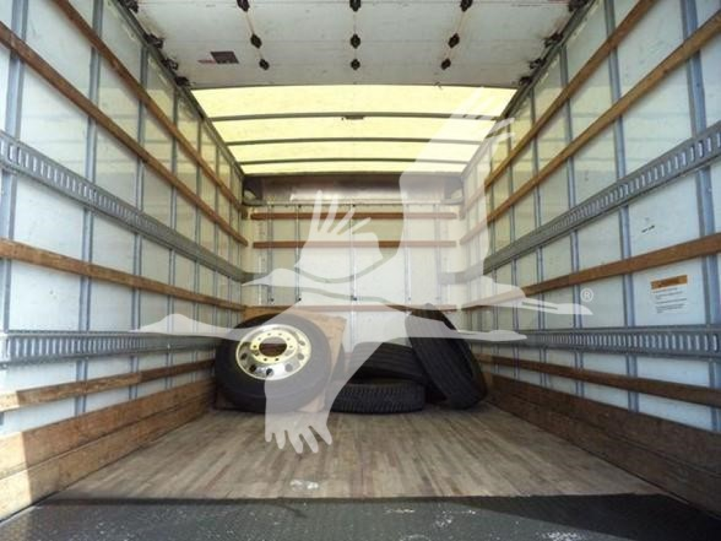 Isuzu NPR HD truck cargo area with spare tires inside empty box truck bed.