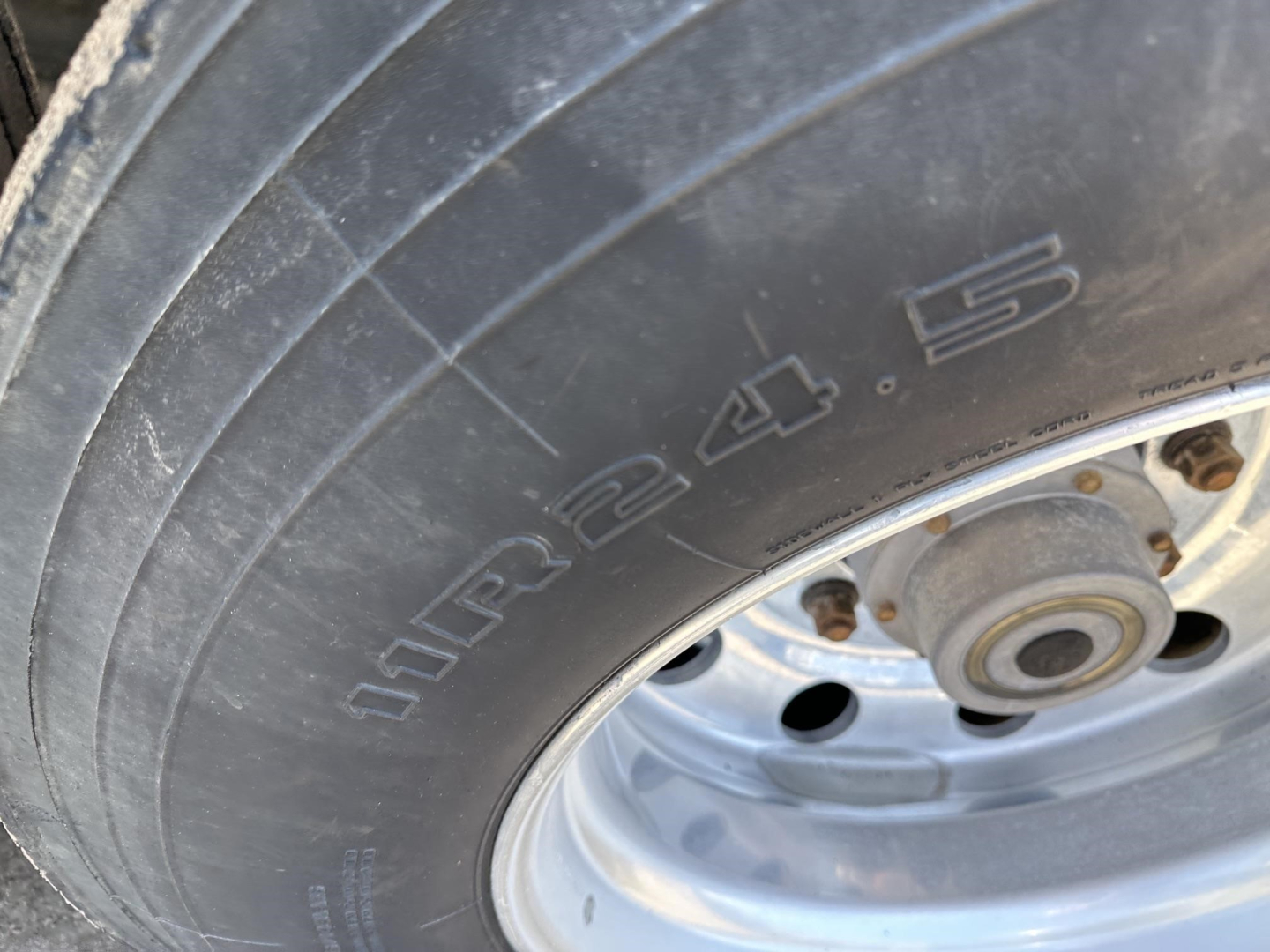 Tire sidewall showing '15.00R22.5' or similar marking on a Polar gravity drop pneumatic trailer wheel, with white rim and hub area visible.
