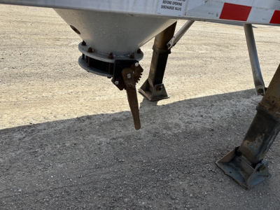 Trailer underside showing gravity drop pneumatic discharge chute with support legs and mounting brackets.