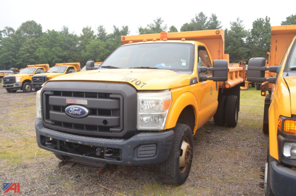 Ford F-350 Super Duty dump truck in service with yellow body and black grille, side view showing dumping bed and front bumper.