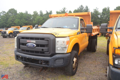 Ford F-350 Super Duty dump truck in service with yellow body and black grille, side view showing dumping bed and front bumper.