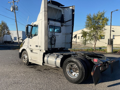 Volvo VNR 300 truck tractor side rear view showing cab and chassis with fuel tanks and wheels.