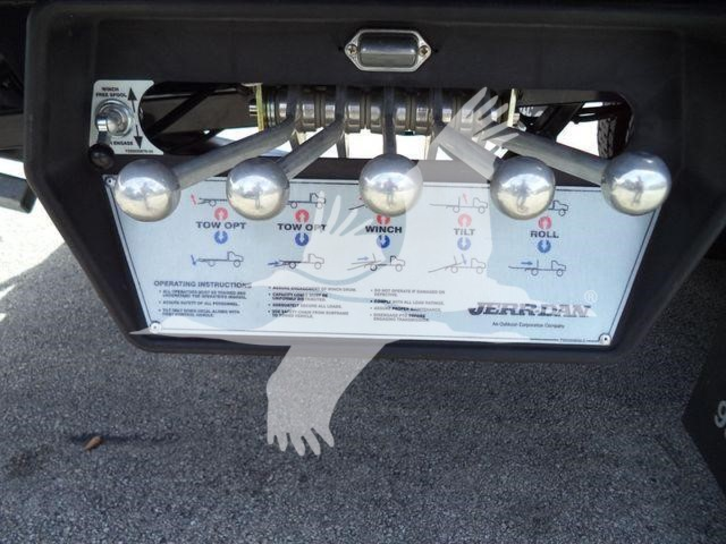 Tow/flip controls panel with multiple levers and labels on a truck rollback, showing instruction diagram and brand logo.