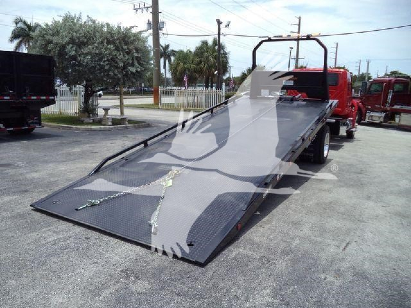 Truck rollback with lowered aluminum ramp bed and red cab, VIN 1HTEUMML1VS478884, stock J78884, new unit in lot.