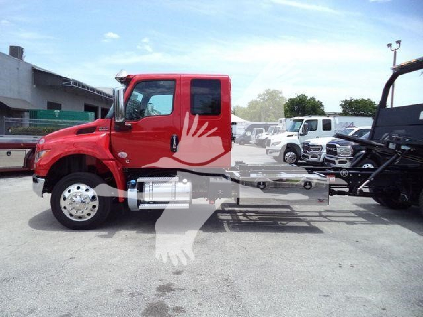Red International MV rollback truck side view showing cab and chassis with extended frame rails, alloy wheels, and side mirrors.