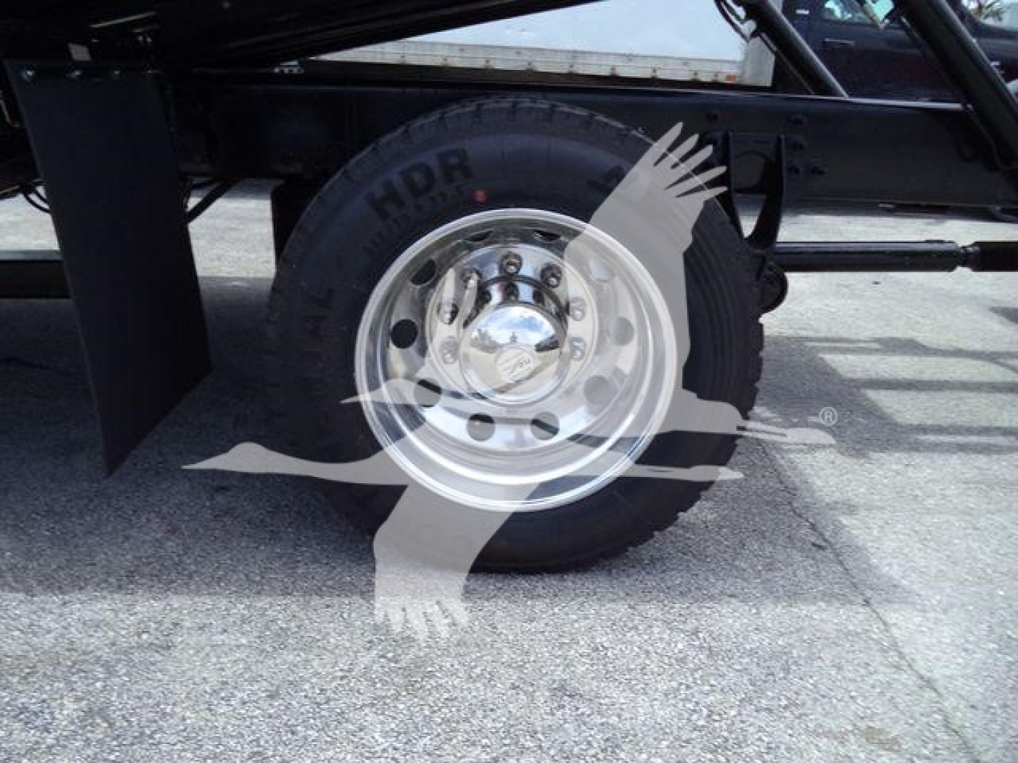 Truck wheel with chrome hubcap and heavy-duty tire on a rollback undercarriage