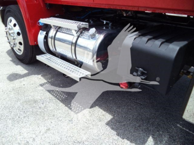 Truck side showing polished aluminum fuel tank with steps and black fender; wheel and mirror visible.