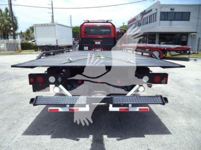 Tow truck rollback bed with platform and dual taillights, metal deck, rear view showing loading ramp area and safety lights.