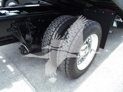 Truck chassis and dual rear wheels showing heavy-duty suspension and tire tread under the rear of a 2027 International MV rollback truck.