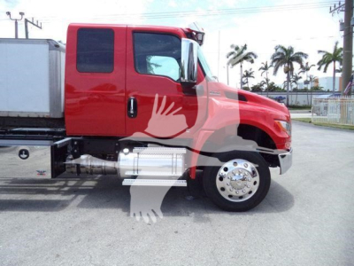 Truck side view showing red International MV rollback with chrome fuel tank and steps, cab door, and wheel details.