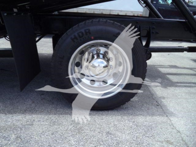 Truck wheel with chrome hubcap and heavy-duty tire on a rollback undercarriage