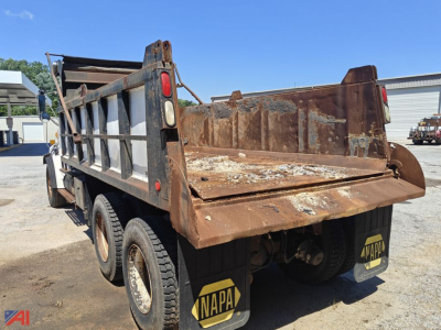 Dump truck showing rusted bed and dual rear axles with mud flaps and NAPA logos.