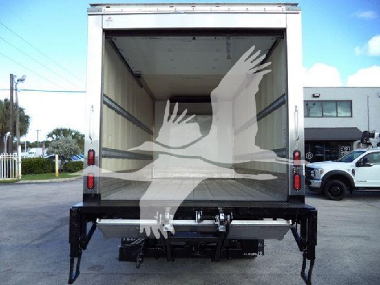 Refrigerated truck with rear cargo doors open showing empty cargo area and lift gate, 2020 Hino 195 model.