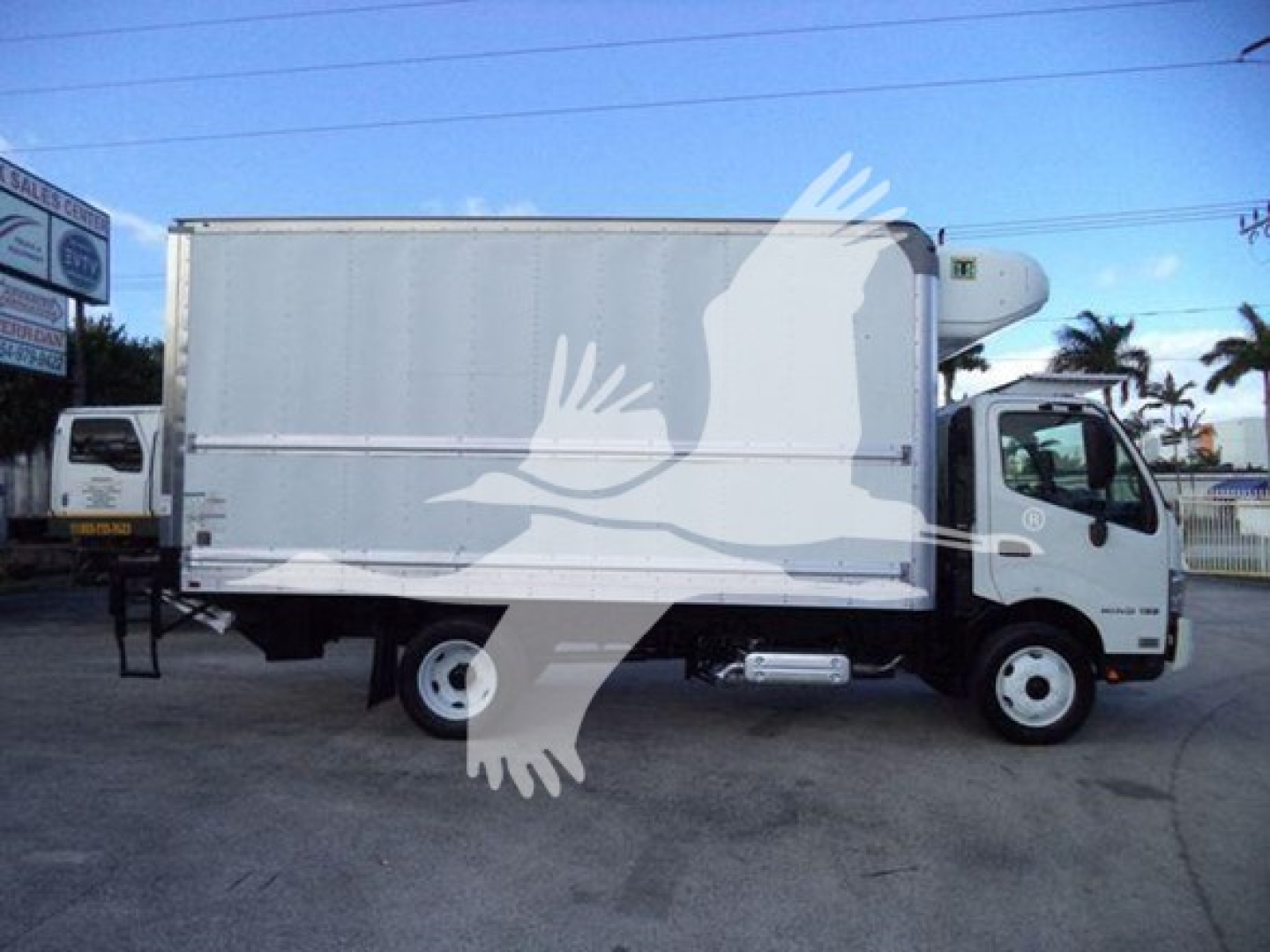 2020 Hino 195 refrigerate truck side view showing cargo box and cab with white exterior.