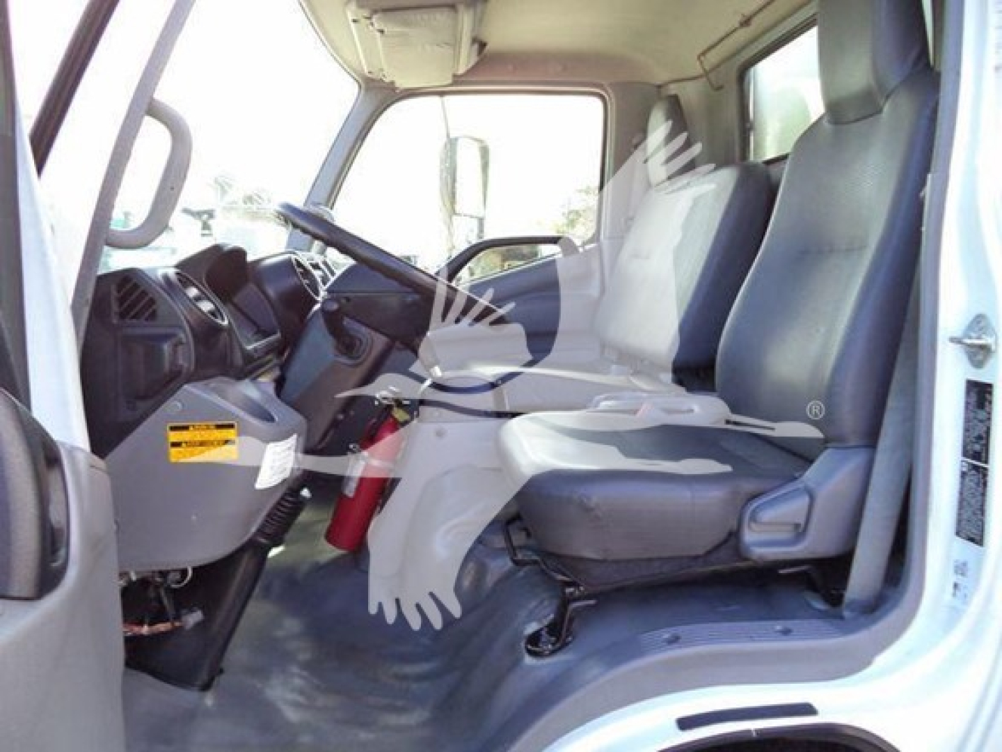 Cab interior of a 2020 Hino 195 refrigerated truck showing driver seat and passenger seat area with dashboard and steering wheel.