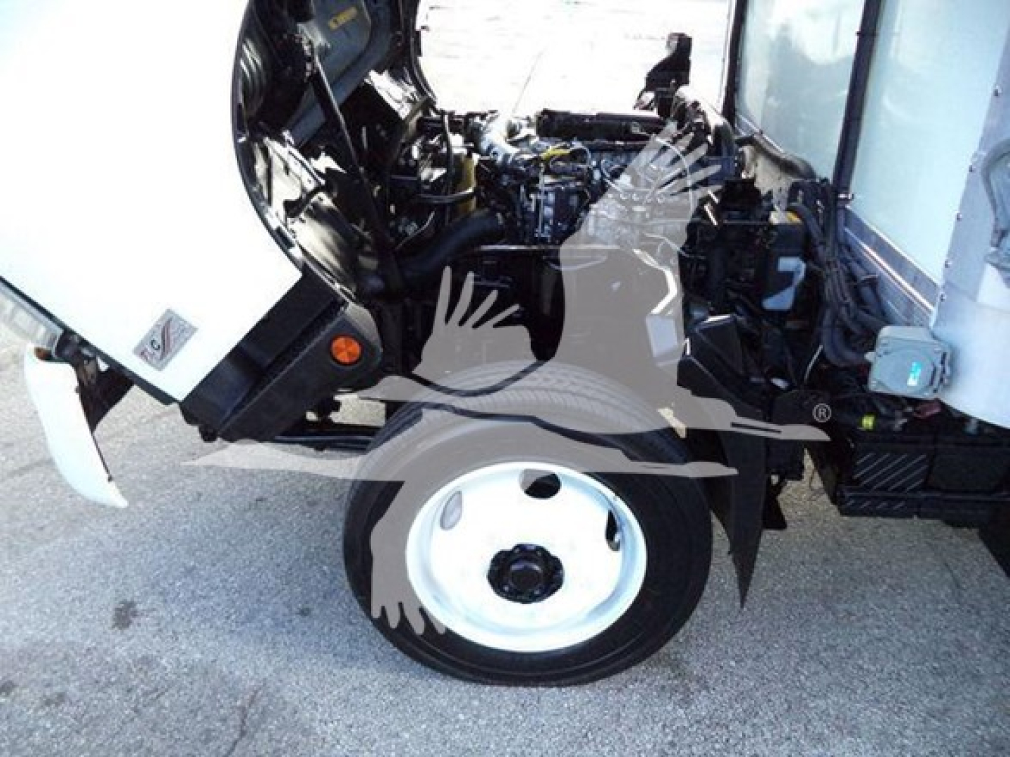 Front section of a 2020 Hino 195 refrigerated truck showing front wheel, open hood with engine bay, and exposed engine components.