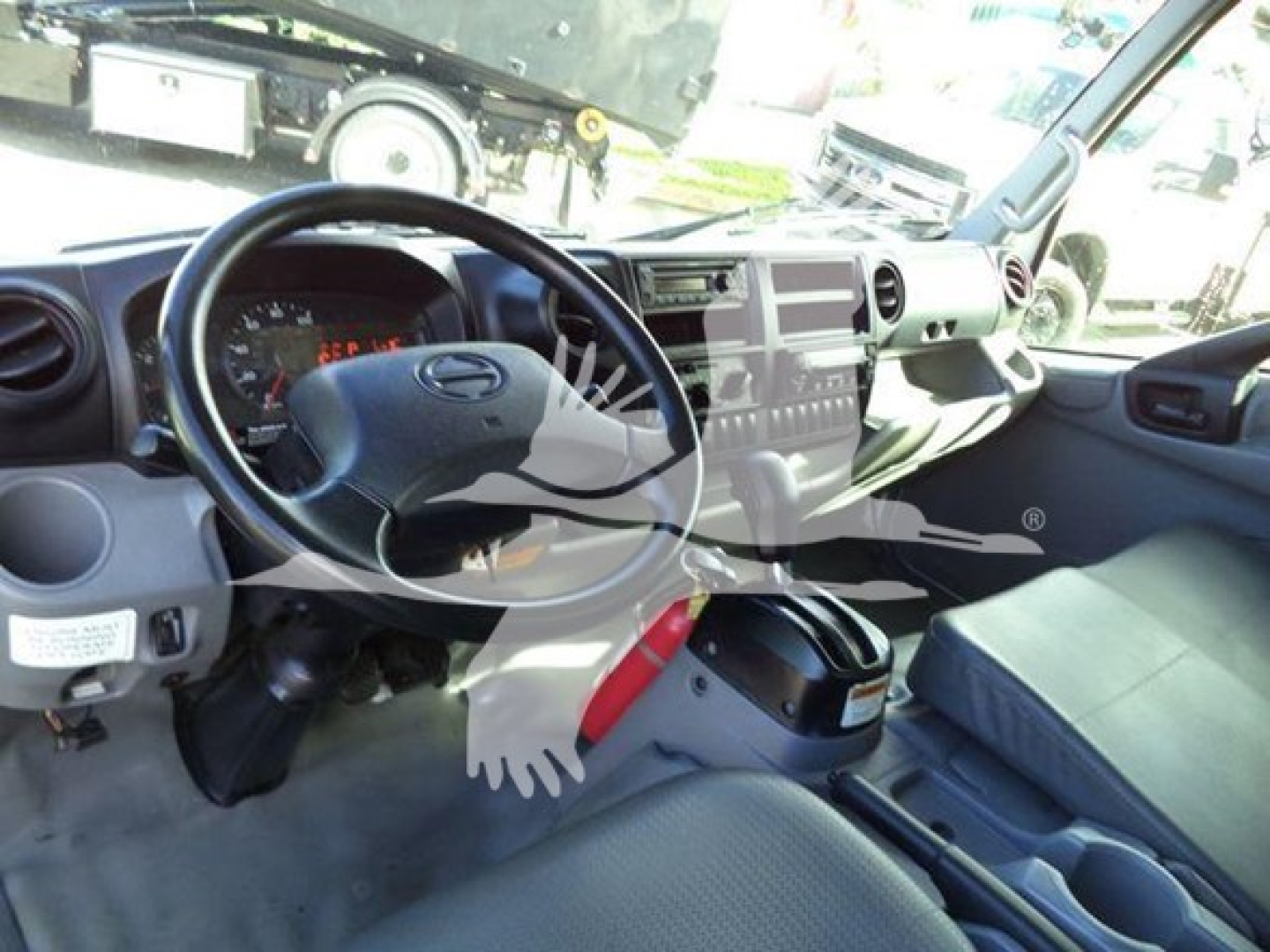 Cab interior of a 2020 Hino 195 refrigerated truck showing steering wheel, dashboard, center console, and seating.