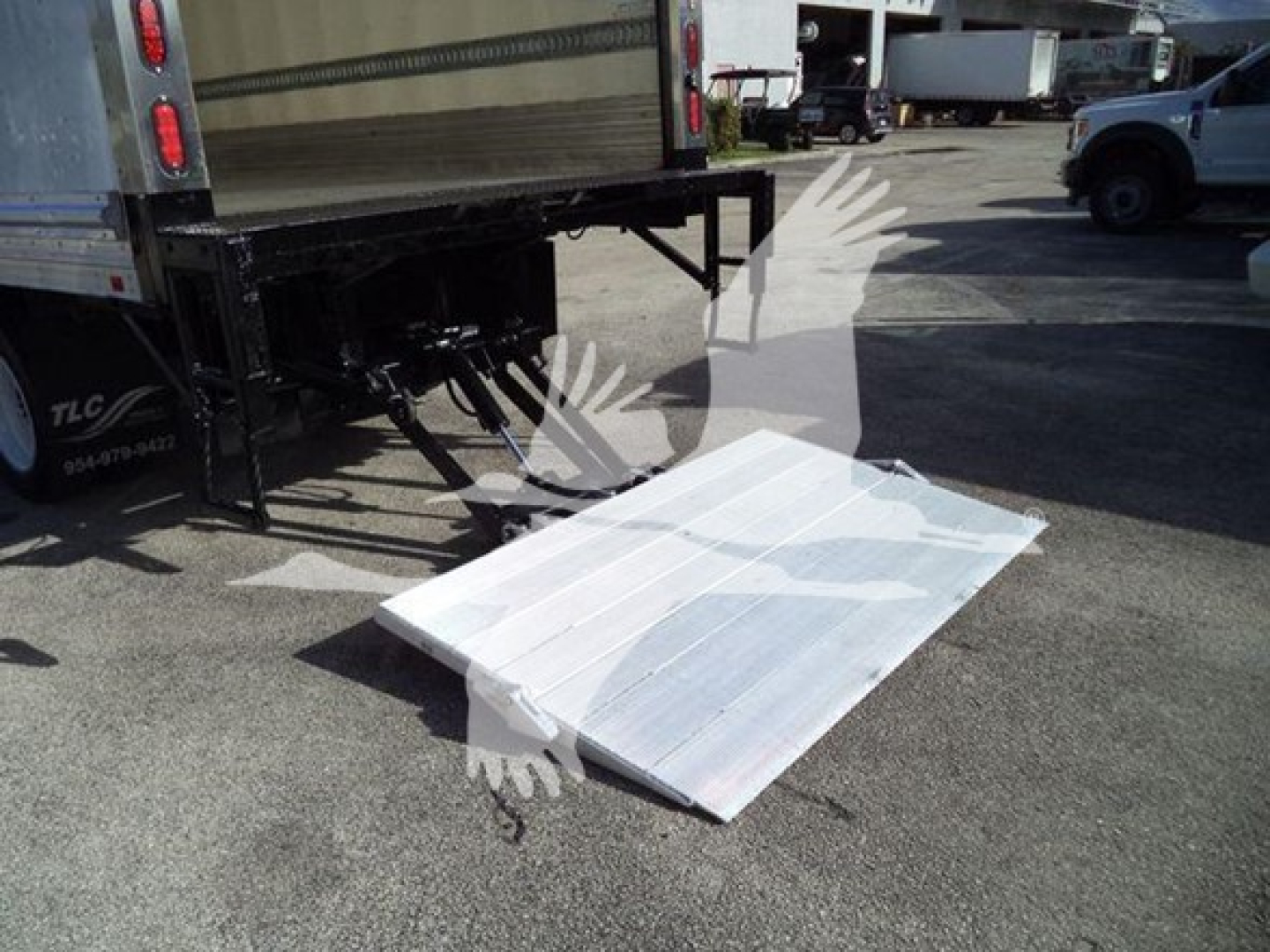 Truck rear with fold-out aluminum ramp/step and refrigerated box area visible