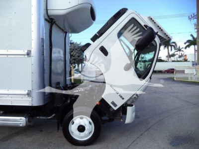 Hino 195 refrigerated truck cab tilted for maintenance angle showing front wheel and door with white and black color scheme.