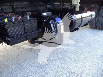 Underbody view of a 2020 Hino 195 refrigerated truck showing the battery box, coolant reservoir with blue cap, and cylindrical component along the chassis.