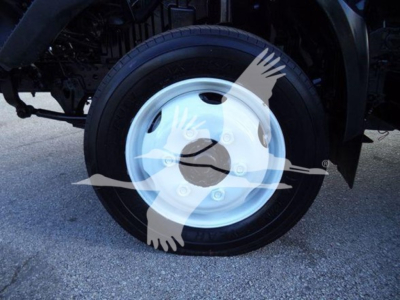 Wheel and tire of a 2020 Hino 195 refrigerated truck showing steel hubcap and tire treads.