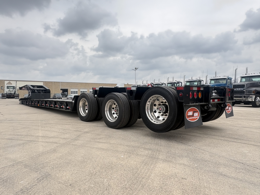 Load King trailer chassis with multiple axles and tires, rear tag says Load King. visible signage and tires border.