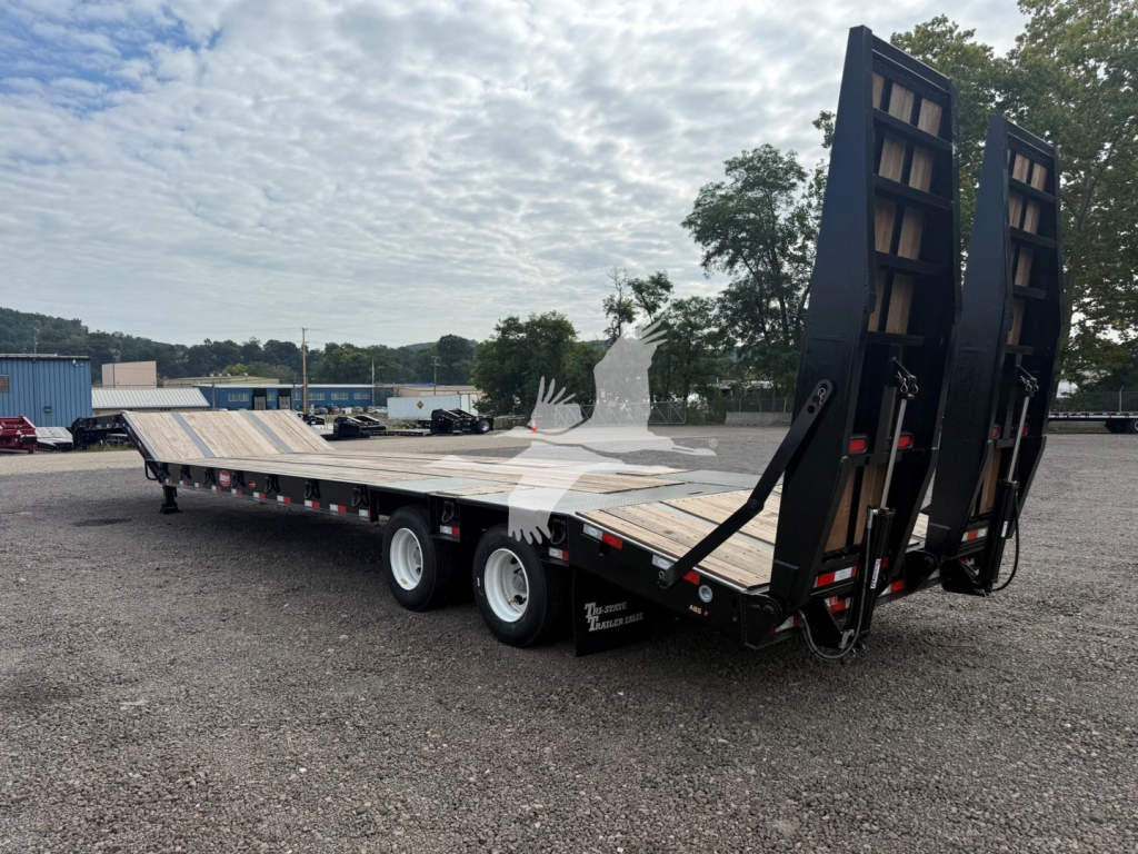 Dorsey LB35-33CS drop deck trailer in a yard showing extended flatbed with ramps up in back and dual rear wheels.