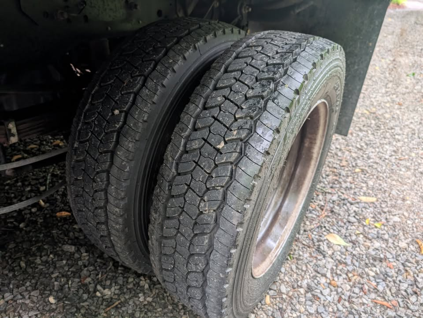Wheel and dual rear tires of a 2022 Ford F-450 Super Duty XL flatbed truck showing tread pattern and outer wheel well.