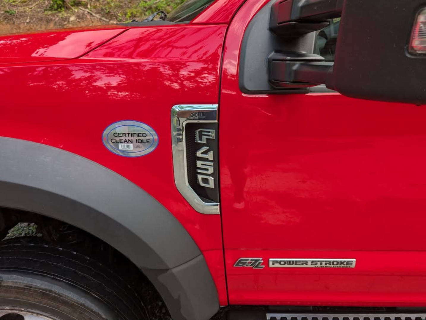 Ford F-450 Super Duty XL side view showing Power Stroke badge and Certified Clean Idle sticker on red truck.