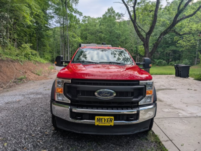 Front view of a red 2022 Ford F-450 Super Duty XL flatbed truck showing Ford emblem grille and Meyer license plate