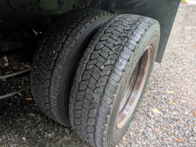 Wheel and dual rear tires of a 2022 Ford F-450 Super Duty XL flatbed truck showing tread pattern and outer wheel well.