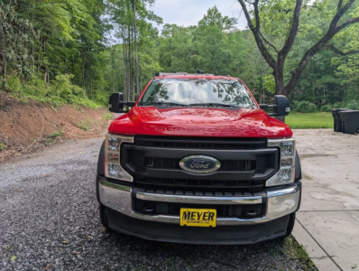 Front view of a red 2022 Ford F-450 Super Duty XL flatbed truck with black grille, chrome bumper, Ford emblem, and Meyer dealer plate.