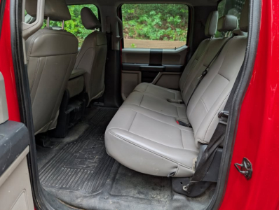 Ford F-450 Super Duty XL interior rear seating with light gray cloth seats and rear door open, showing back row and cargo area.