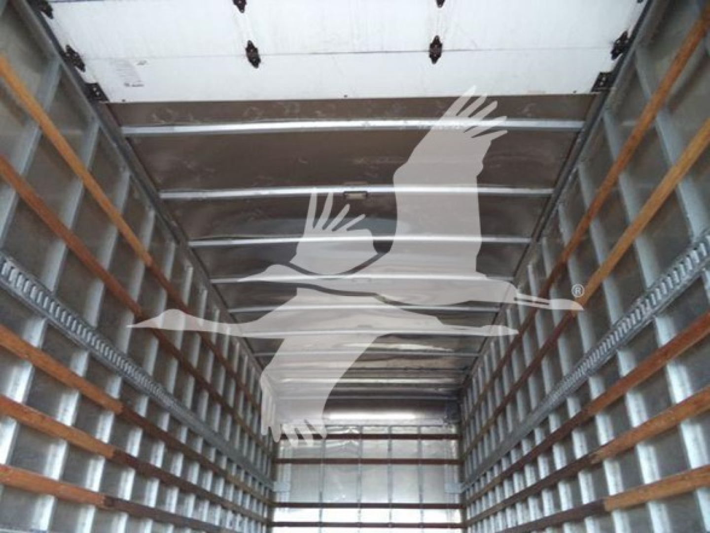 Interior cargo area of a Freightliner M2 106 box truck showing metal side rails and wooden cleats.