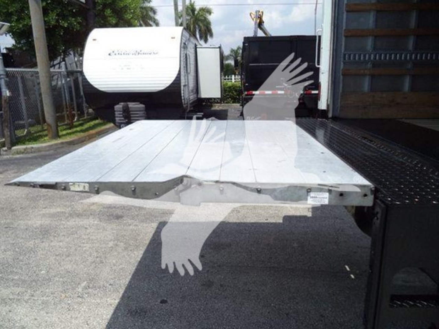 Freightliner M2 106 flatbed platform seen from rear of truck, aluminum bed with hinge areas and mounting points visible.
