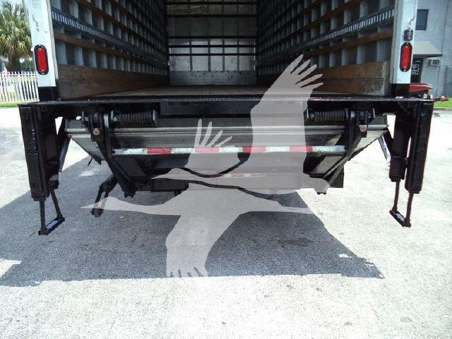 Freightliner M2 106 rear view showing undercarriage and tail area with liftgate supports and hydraulic lines.