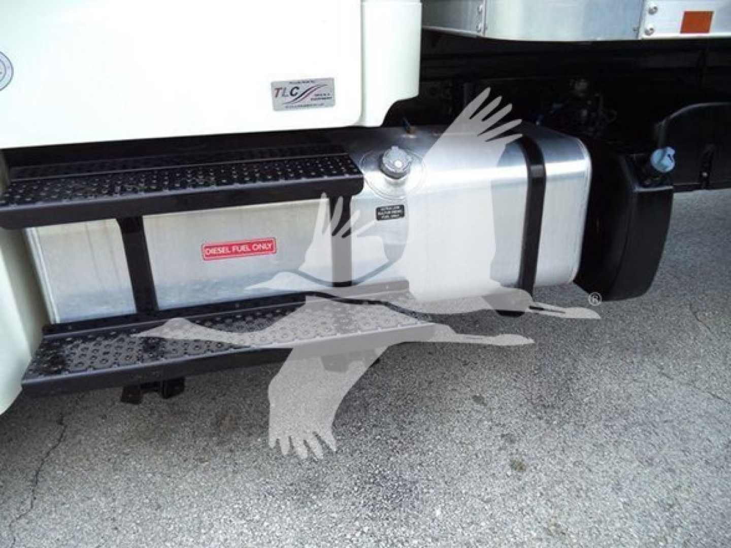 Truck side showing fuel tank and step area of Freightliner M2 106 with steps and tank markings.