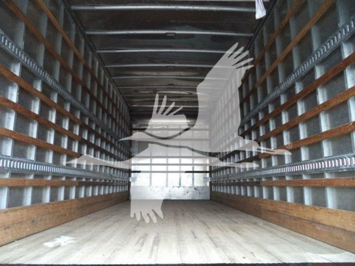 Freightliner M2 106 truck cargo area showing empty box bed with wooden floor and metal side rails.