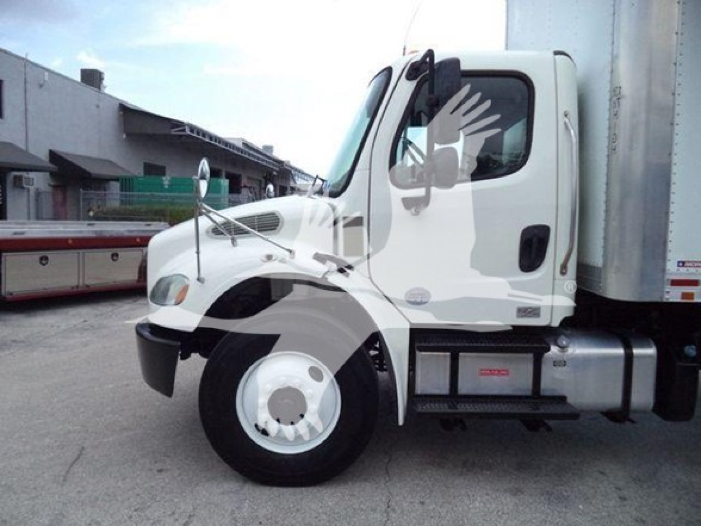 Freightliner M2 106 truck cab side view showing front wheel and fuel tank with cab door. Visible text on stickers
