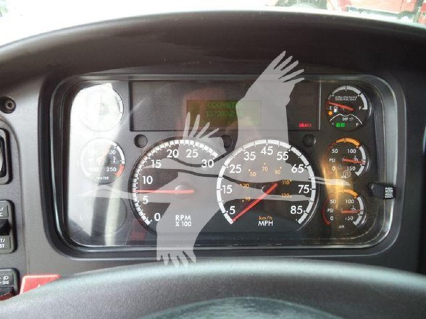 Truck dashboard/controls showing speedometer, tachometer, and gauges; no legible model text visible.