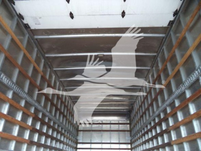 Interior cargo area of a Freightliner M2 106 box truck showing metal side rails and wooden cleats.