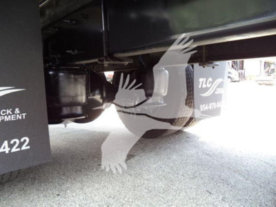 Underneath Freightliner M2 106 chassis showing suspension and hitch area with partial text '954-' visible on a plate.