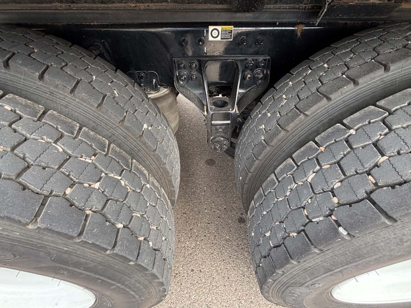 Kenworth truck chassis showing dual rear tires and suspension mounting bracket.