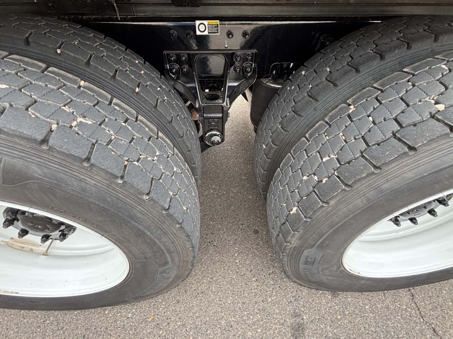 Kenworth T880 truck rear dual tires and suspension components showing hub area and frame.