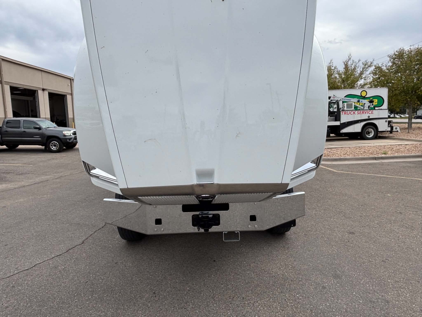 Front view of a Kenworth T880 dump truck showing the front bumper and hitch area with a silver underride guard.