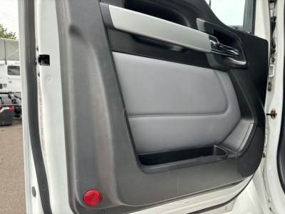 Door interior of a white Kenworth T880 showing light gray door panel with black lower trim and chrome handle.